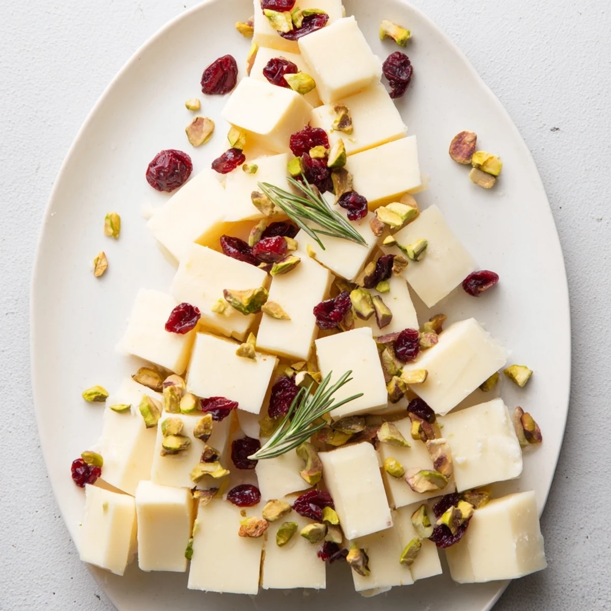 Beautifully constructed Cranberry White Cheddar Tree with vibrant red cranberries and green rosemary offers a flavorful, easy appetizer.