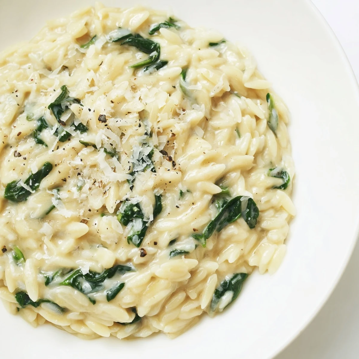 Creamy Spinach Orzo, a vibrant one-pan dish, served hot and garnished with fresh Parmesan cheese.