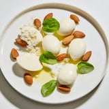 Enjoy a visual feast of The Polished Pebble, an elegant arrangement with oval cheeses and toasty almonds.