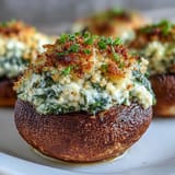 Creamy spinach and ricotta filling nestled in tender mushroom caps, baked until savory aroma fills the kitchen.  