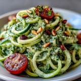 Creamy Avocado Pesto coats tender zucchini noodles, perfect for a quick, light weeknight dinner.