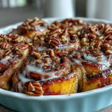 Fluffy, warm Peach Cobbler Cinnamon Roll Casserole topped with creamy icing drizzle.