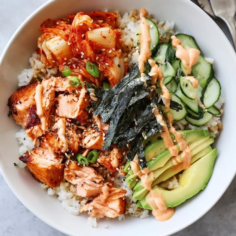 Crispy Salmon Rice Bowl topped with spicy mayo, kimchi, and fresh avocado slices.  
