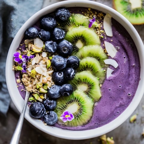 Vibrant smoothie bowls featuring purple yam, pistachios, and fresh fruit toppings.  