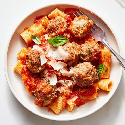 Hearty Italian Meatball Pasta Skillet topped with melted cheese and fresh basil.   