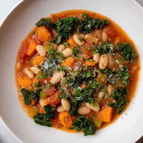Steaming Italian Bean & Kale Stew, a vibrant medley of beans, greens, and flavorful broth, ready to eat.