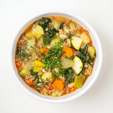Steaming bowl of Minestrone with Quinoa & Winter Greens garnished with fresh parsley, ready to eat.