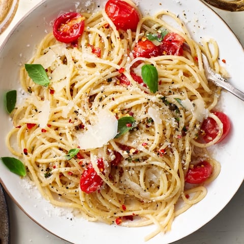 Steaming bowl of Lazy-Girl Pasta, glistening with Parmesan, and fresh basil, ready to eat.