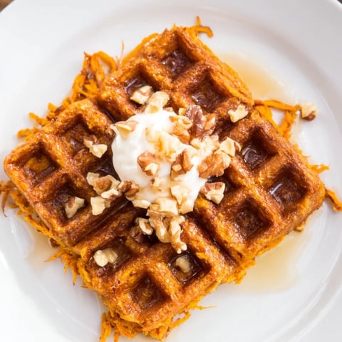 Fluffy sweet potato waffles, golden-brown and crispy, ready to be enjoyed with fresh fruit.