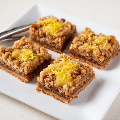 Golden-brown Lemon-Glazed Gingerbread Crumble Bars, drizzled with tangy glaze, a perfect dessert.