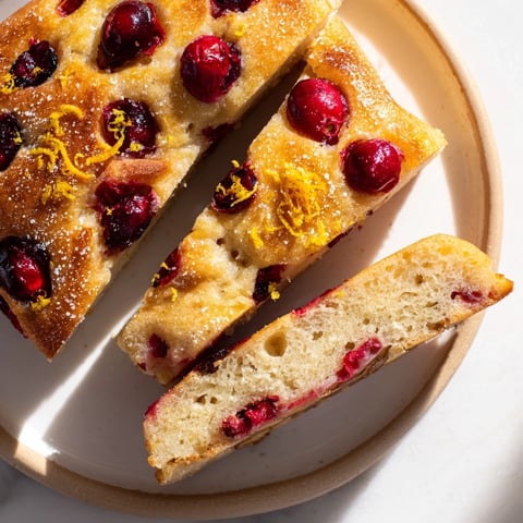 Golden-brown Cranberry Orange No-Knead Focaccia topped with bright cranberries and orange zest.