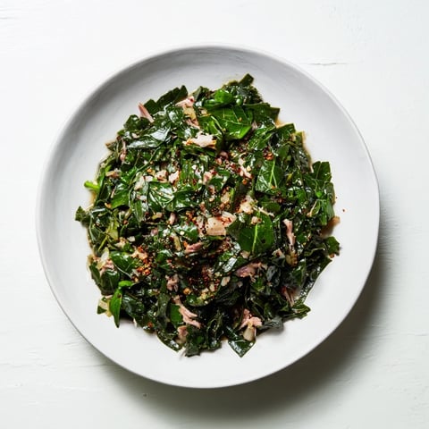 Southern-style collard greens with smoked turkey, featuring tender greens and smoky turkey visible in a hearty bowl.