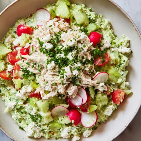 A creamy, vibrant Green Goddess Chicken Nacho Dip, garnished with fresh herbs and served with chips.
