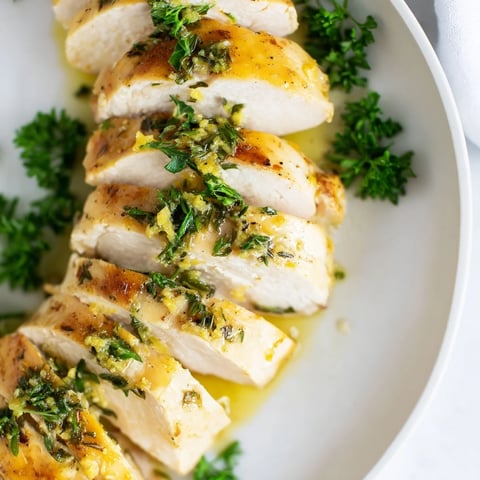 Golden, baked Greek Lemon Herb Chicken, glistening with flavorful marinade and fresh herbs ready to serve.
