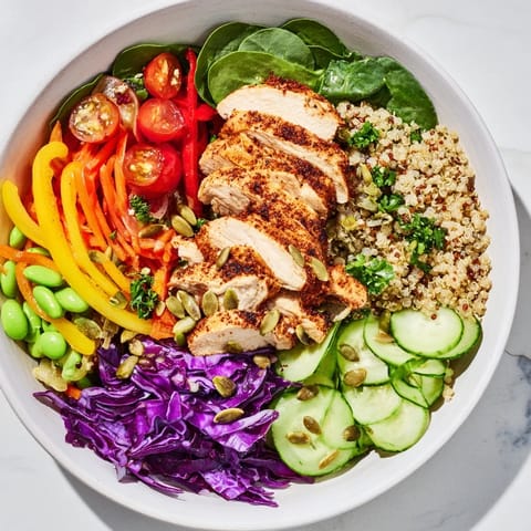 Colorful layers of Healthy Meal-Prep Bowls topped with grilled chicken and fresh dressing.  