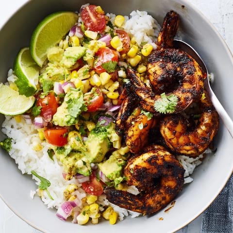 Blackened shrimp bowl topped with creamy avocado corn salsa and fluffy rice.  