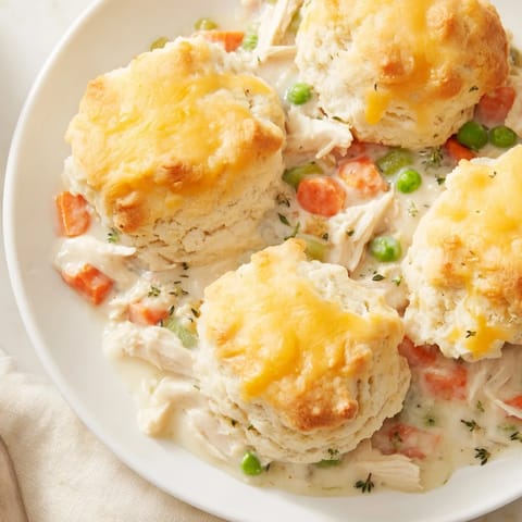Savory One-Pan Chicken Cobbler showcasing a creamy chicken and vegetable filling beneath a baked biscuit crust.