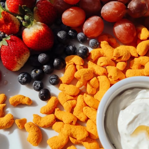 Bright rainbow Goldfish crackers and fresh fruit create a visually appealing, healthy snack platter.
