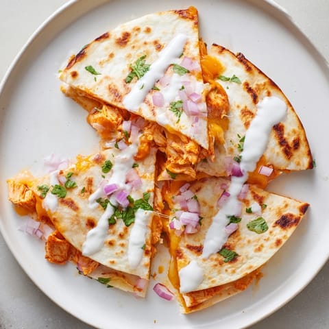 Golden-brown Buffalo Chicken Quesadilla, oozing with cheese, served with ranch dressing for dipping.