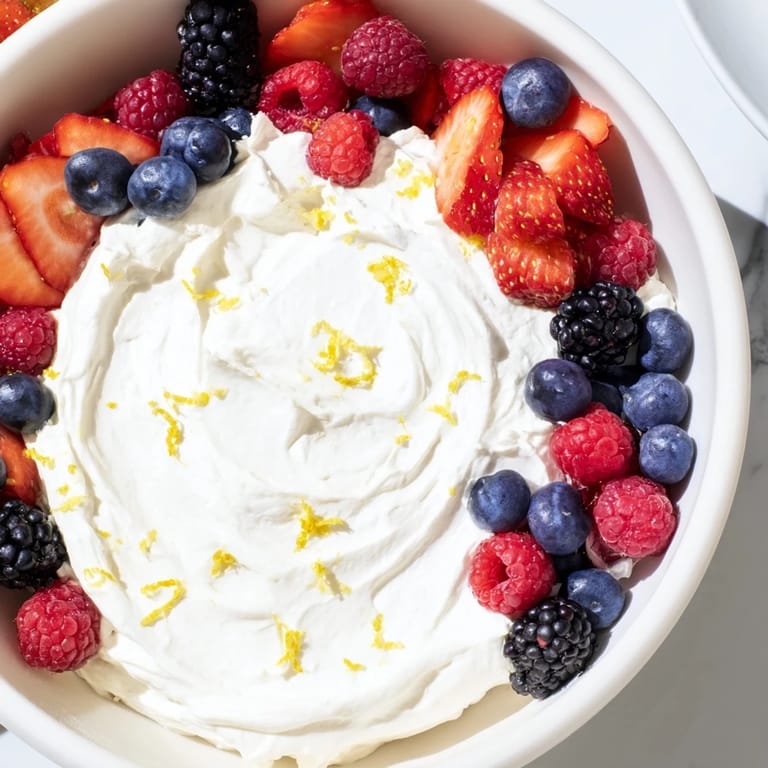 Cool, fluffy cream cheese fruit dip served alongside colorful, fresh, juicy berries for dipping.