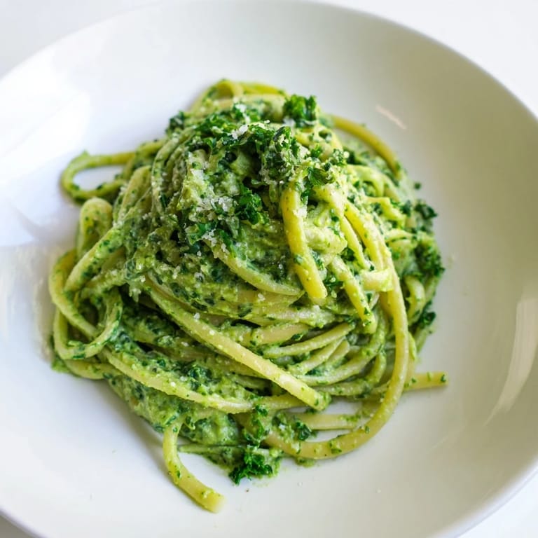 A bowl of delicious Green Goddess Pasta Sauce, ready for serving with optional extra Parmesan cheese.