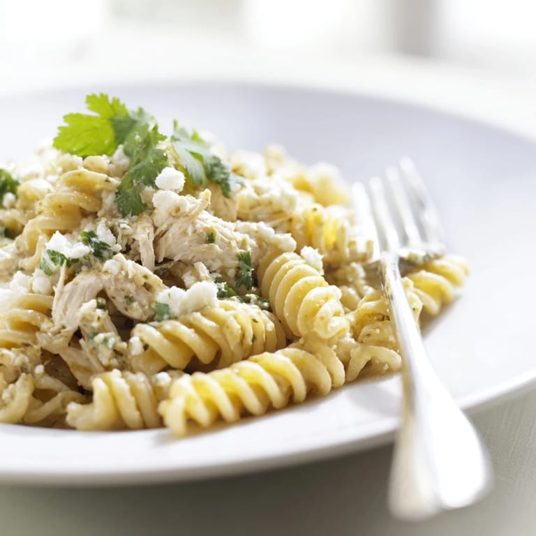 A fresh cilantro lime chicken pasta dinner with extra herbs and a side of lime, ready to enjoy.
