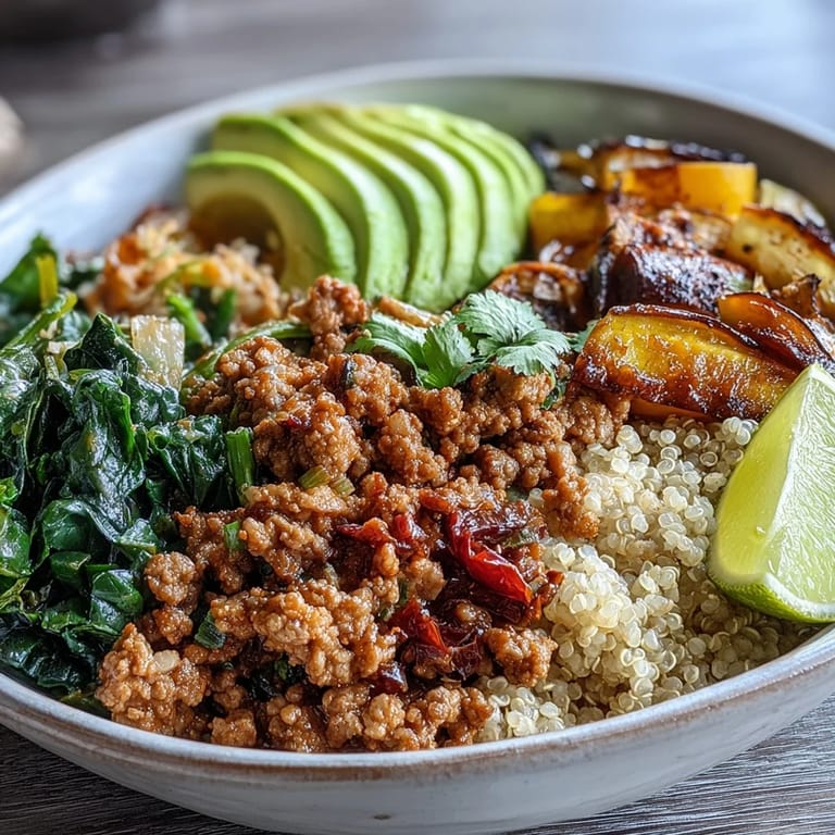A nutritious Ground Turkey Bowl with colorful roasted vegetables, fluffy quinoa, and sliced avocado, ready to be enjoyed with lime wedges.