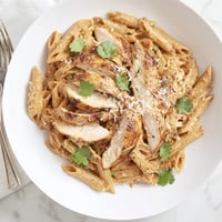 Creamy honey chipotle chicken pasta with seared chicken, penne, and fresh cilantro garnish.