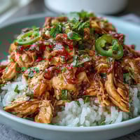 Crockpot Mississippi Chicken Rice Bowls with tender shredded chicken and zesty pepperoncini over fluffy rice.  