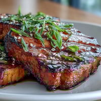 Miso glazed eggplant halves roasted until tender, topped with a sweet and savory miso glaze, garnished with sesame seeds and green onions.  